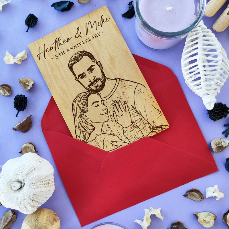 Laser engraved couple portrait on wooden greeting card — personalized anniversary gift with red envelope.